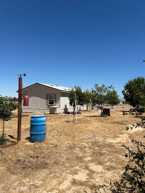 a backyard of a house with wooden fence and large trees