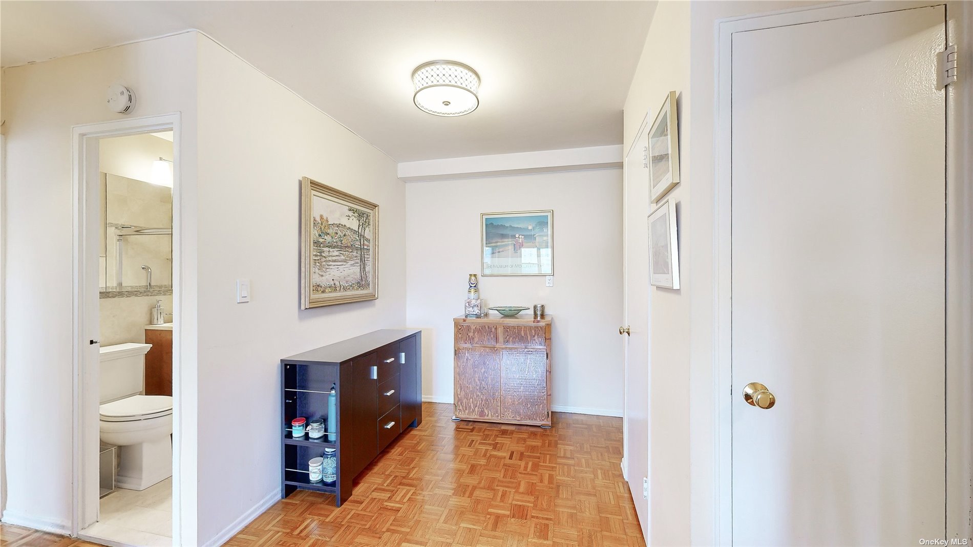 a spacious bathroom with a toilet a sink and a large mirror