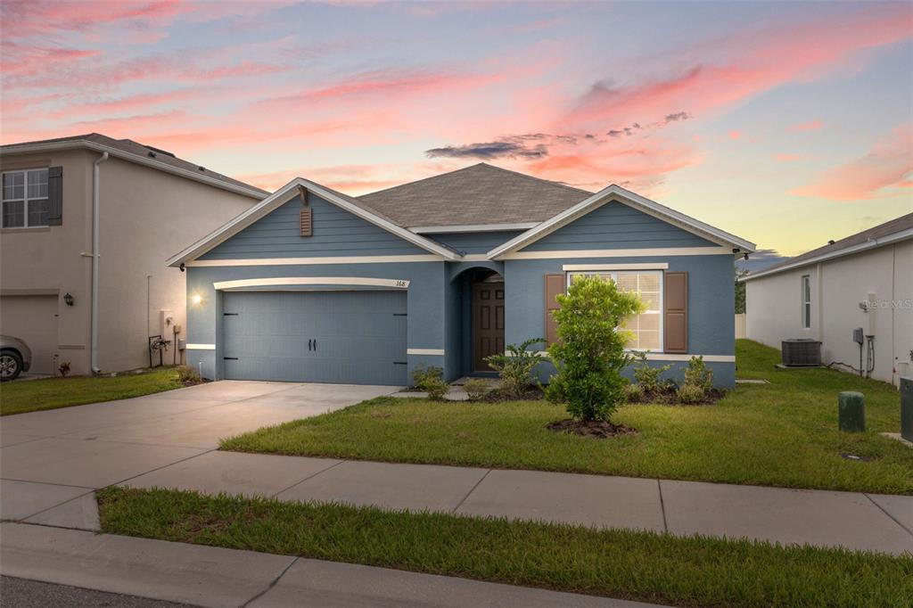 a front view of a house with a yard and garage