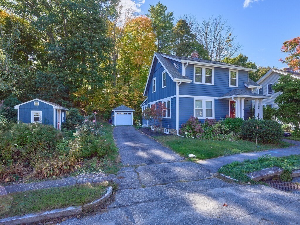 a view of a brick house next to a yard with plants and trees