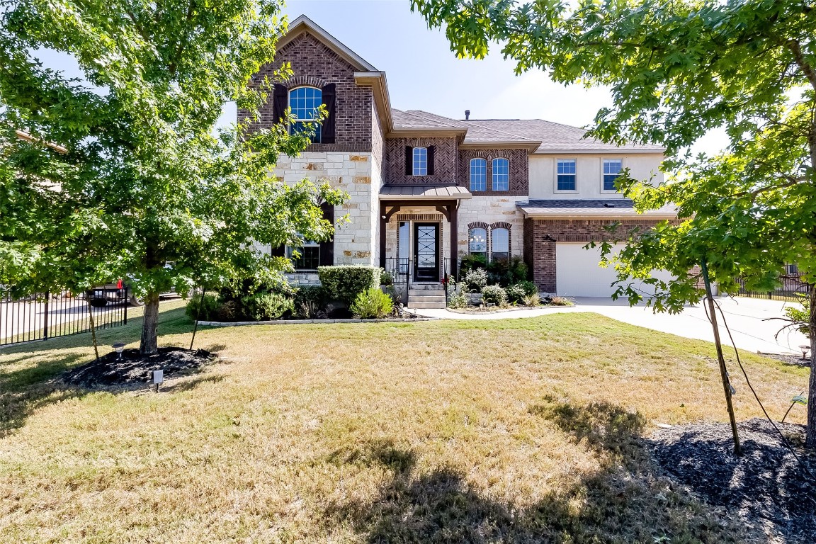 a front view of a house with a yard and tree s