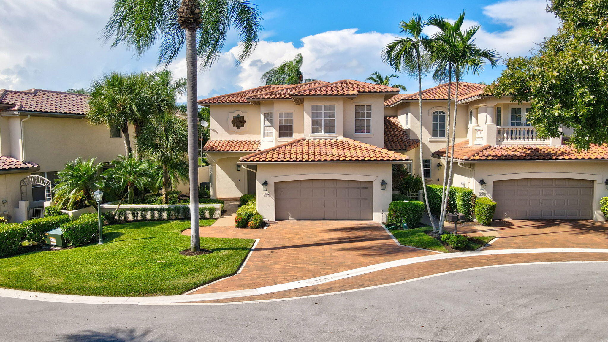 a front view of a house with a yard and potted plants