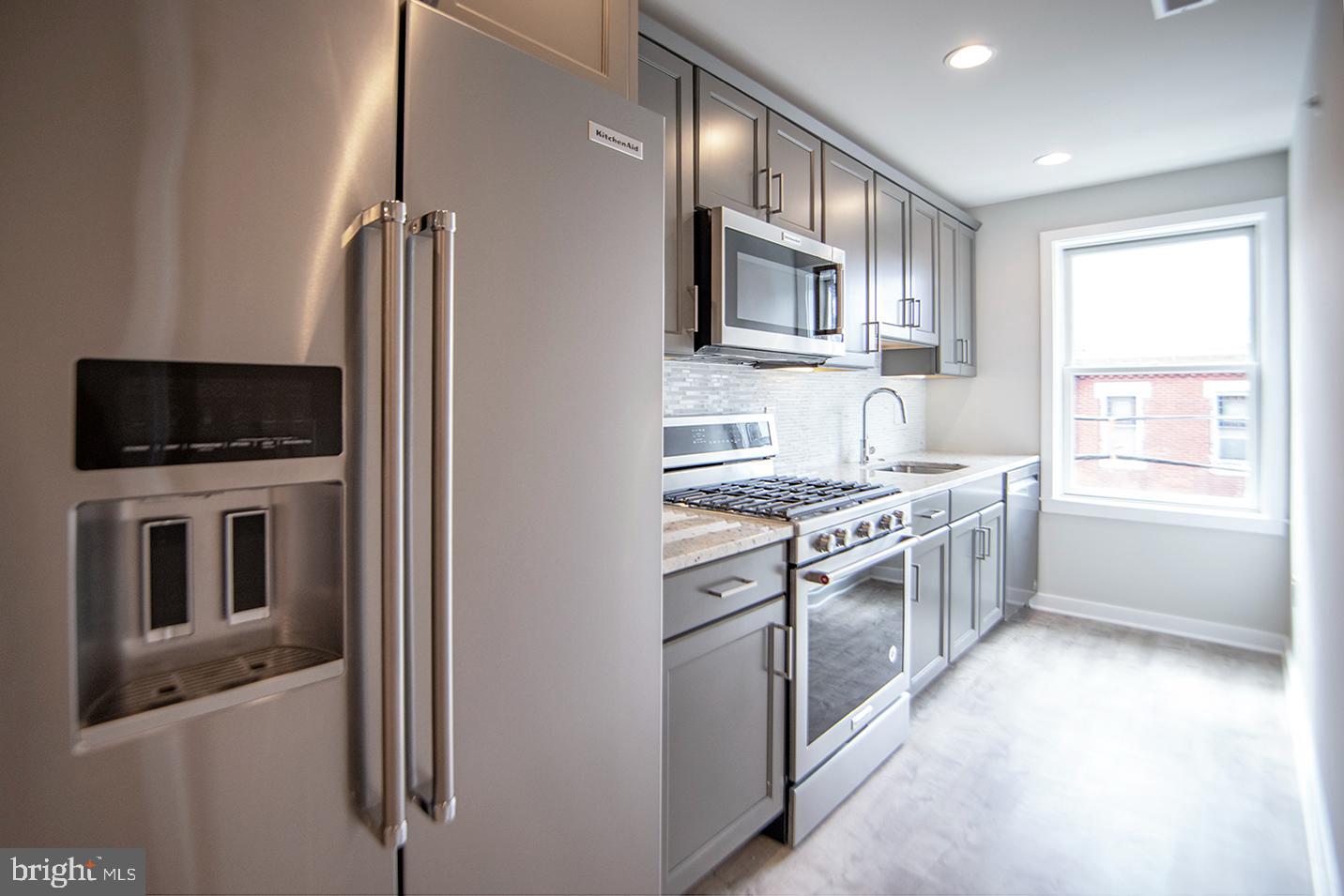 a kitchen with a sink stove and microwave