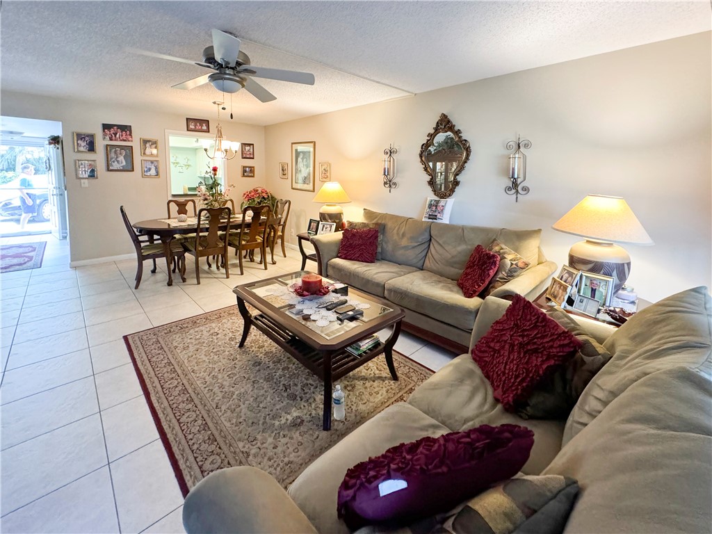 a living room with furniture and a dining table with wooden floor