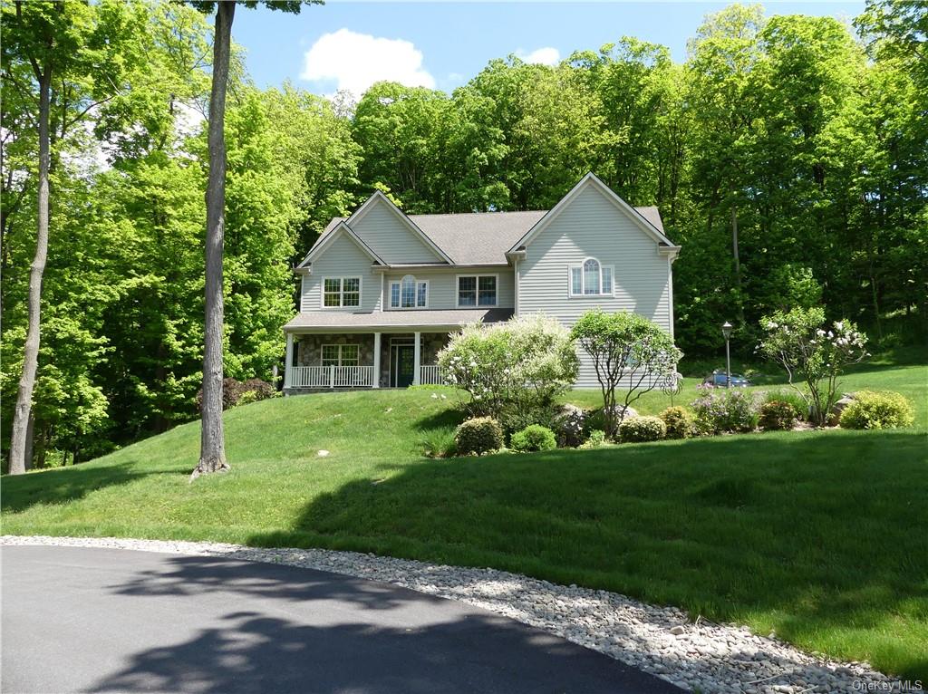 a front view of a house with a yard and trees