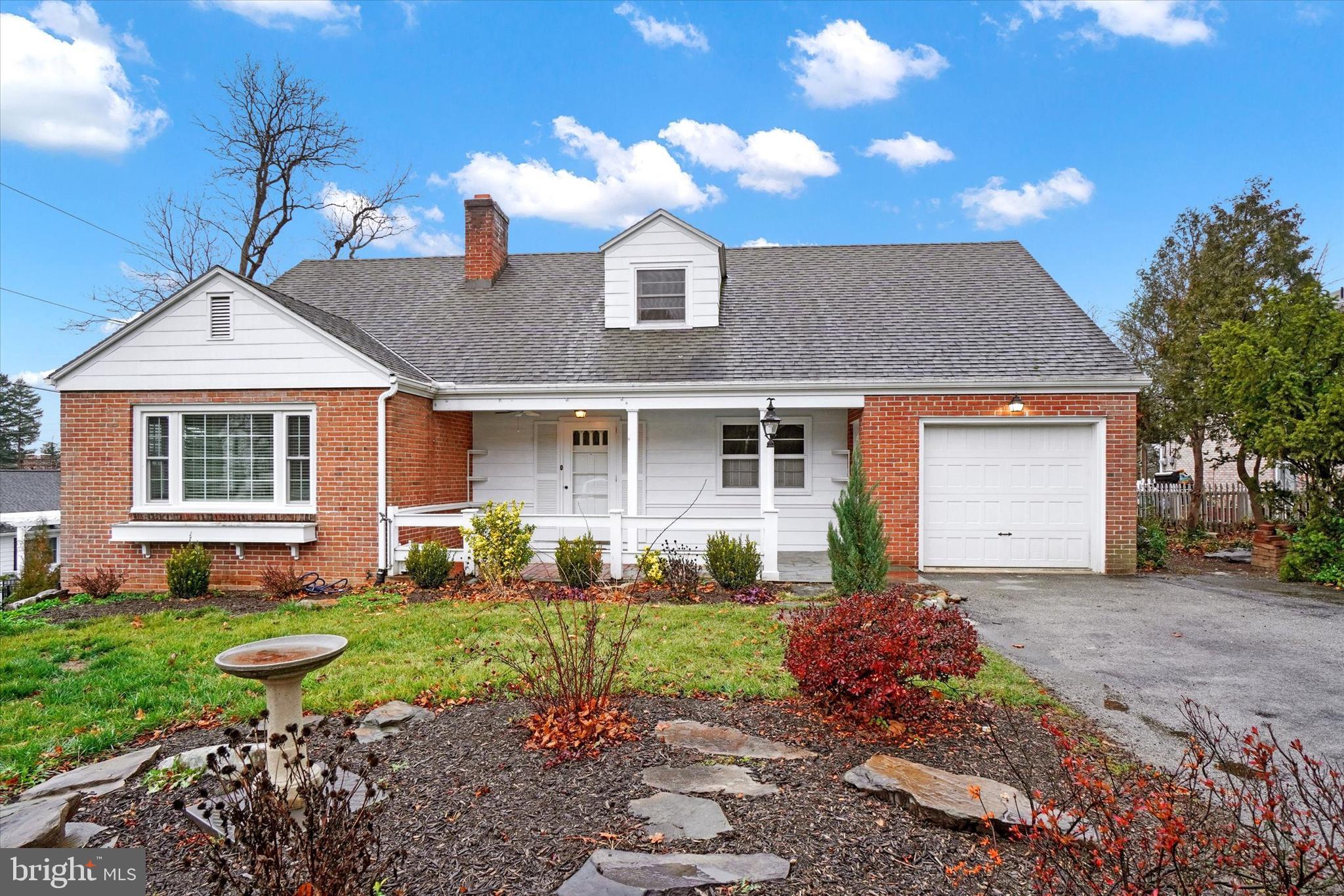 a front view of a house with a yard and outdoor seating