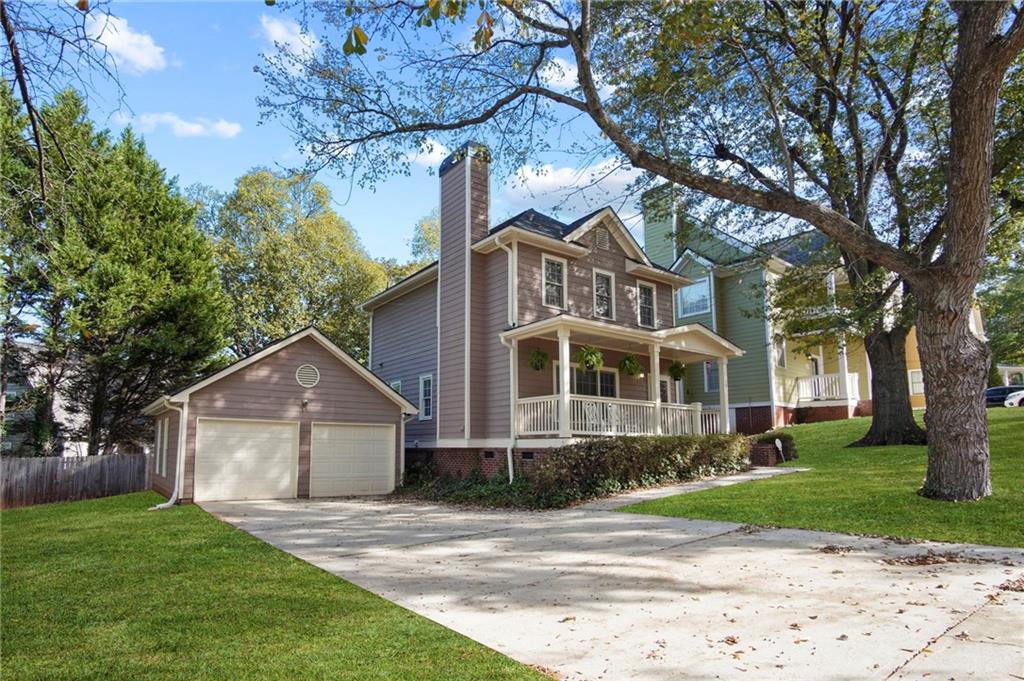 a front view of a house with a yard and trees