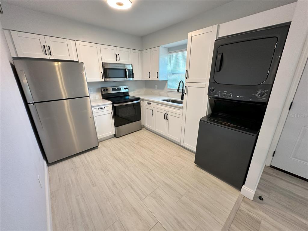 a kitchen with a refrigerator a stove top oven a sink and dishwasher