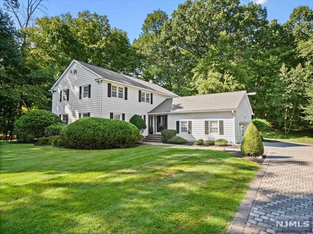 a front view of a house with a yard and trees