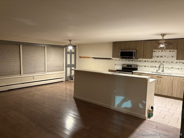 a kitchen with kitchen island a sink stainless steel appliances and cabinets