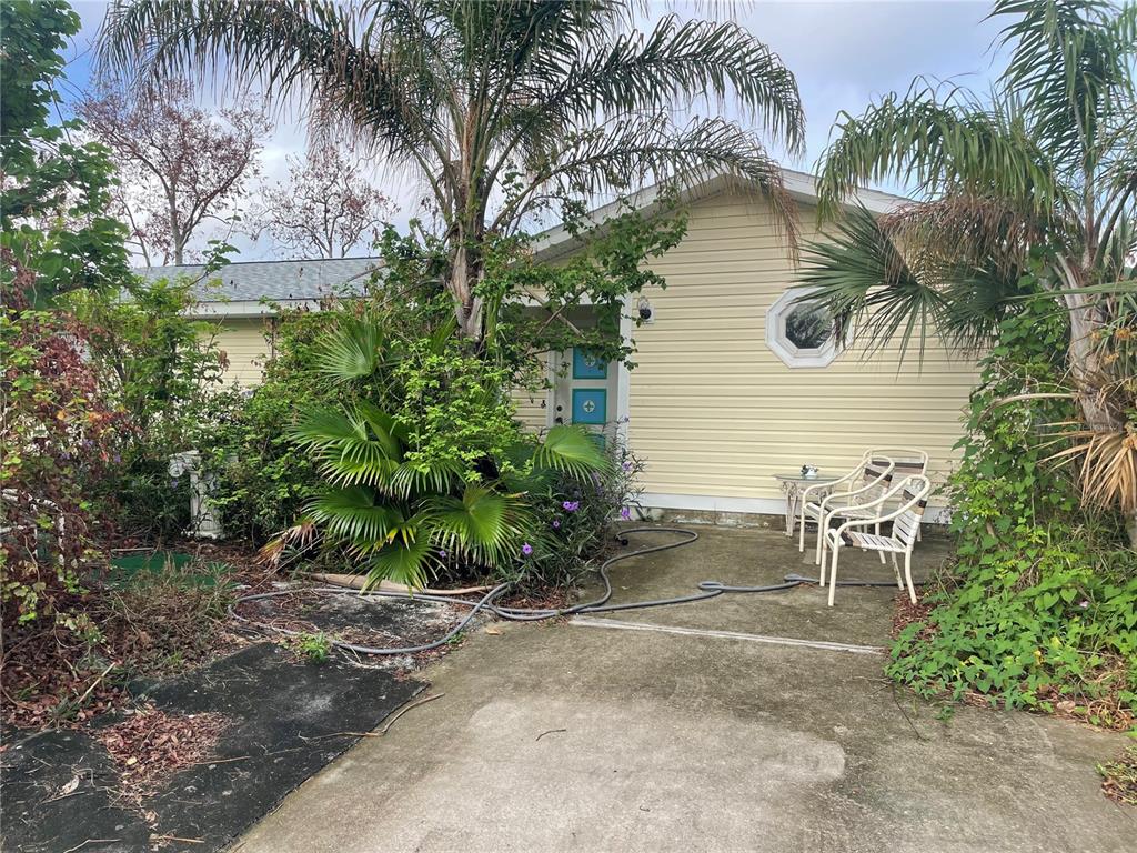 a backyard of a house with table and chairs under an umbrella