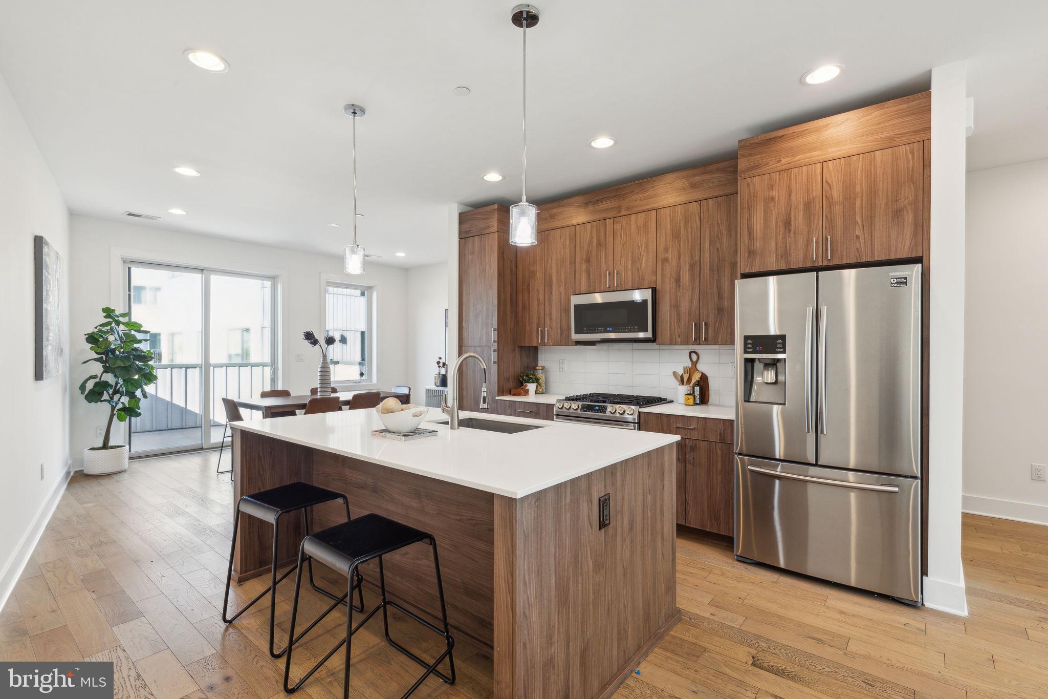 a kitchen with kitchen island a counter top space stainless steel appliances and cabinets