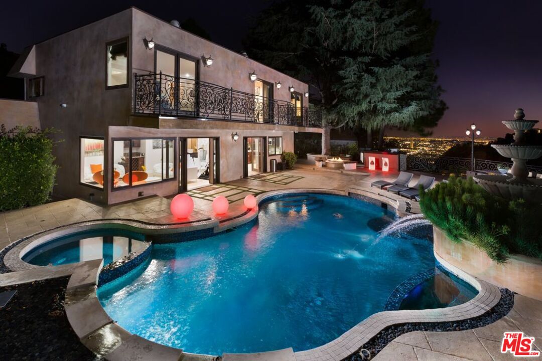 a view of a swimming pool in the backyard of house along with seating space