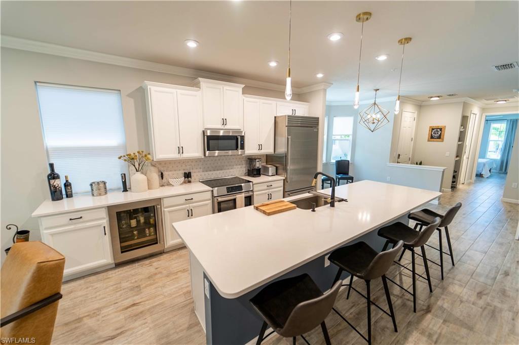 a large kitchen with kitchen island a stove a sink a dining table and chairs