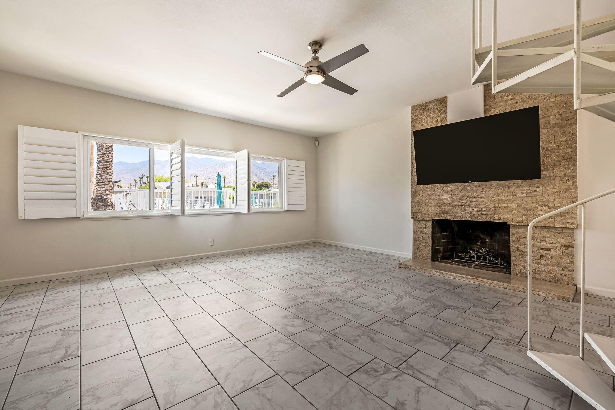 a view of an empty room with a fireplace and a window