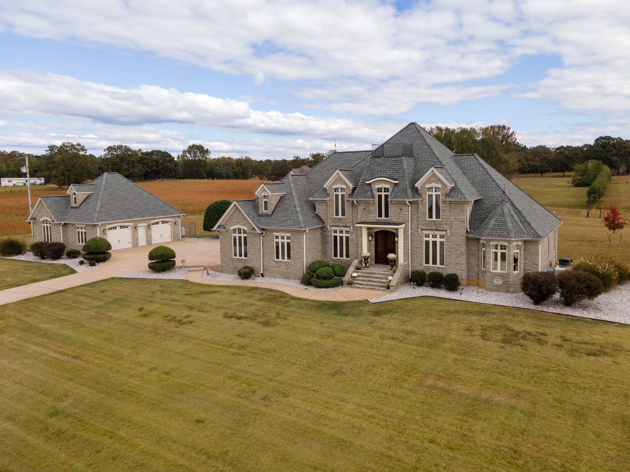 a view of a house with a big yard and large trees