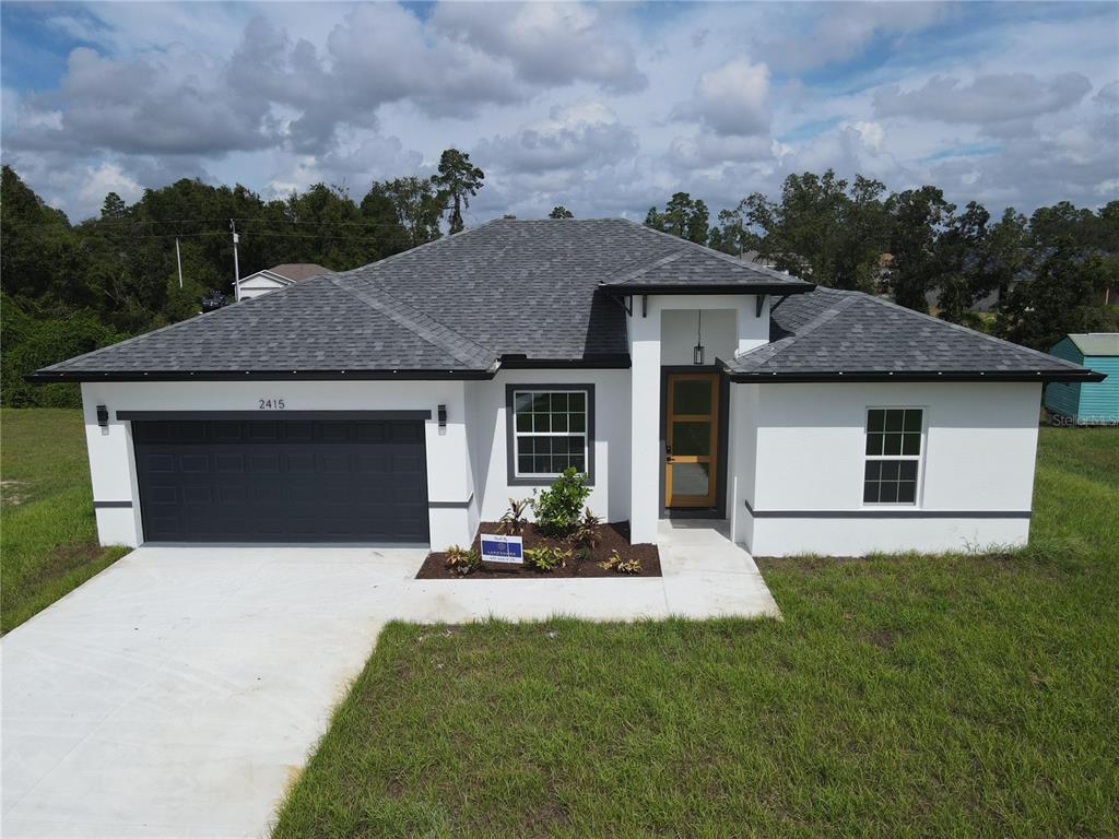 a front view of a house with a yard and garage