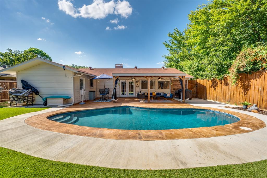 a view of pool with umbrella and trees in the background