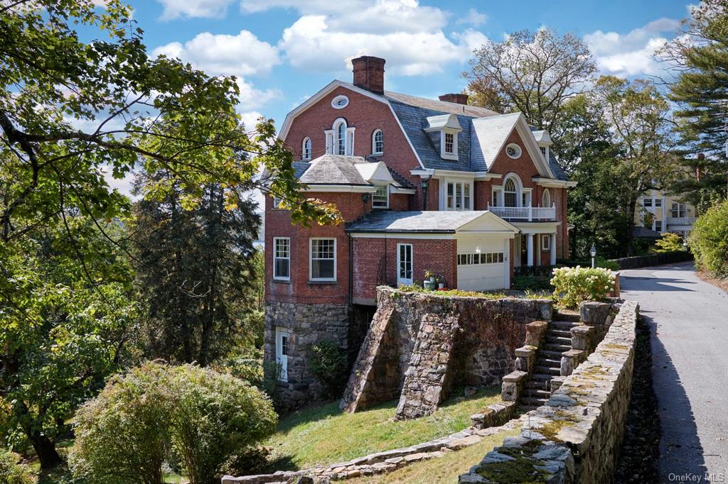 View of front of property featuring a garage and a balcony