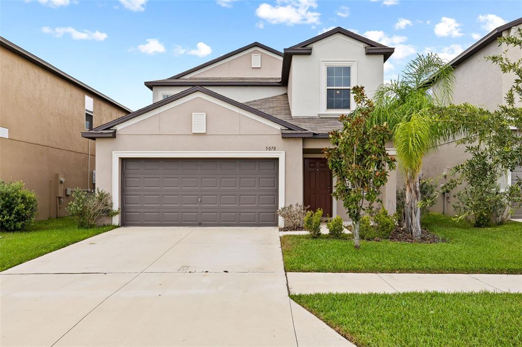 a front view of a house with a yard and garage