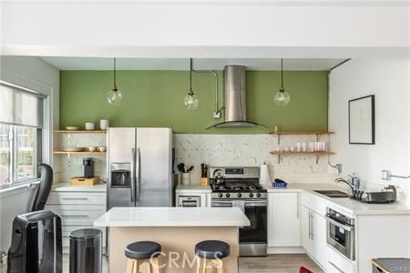 a kitchen with stainless steel appliances granite countertop a refrigerator and a stove top oven