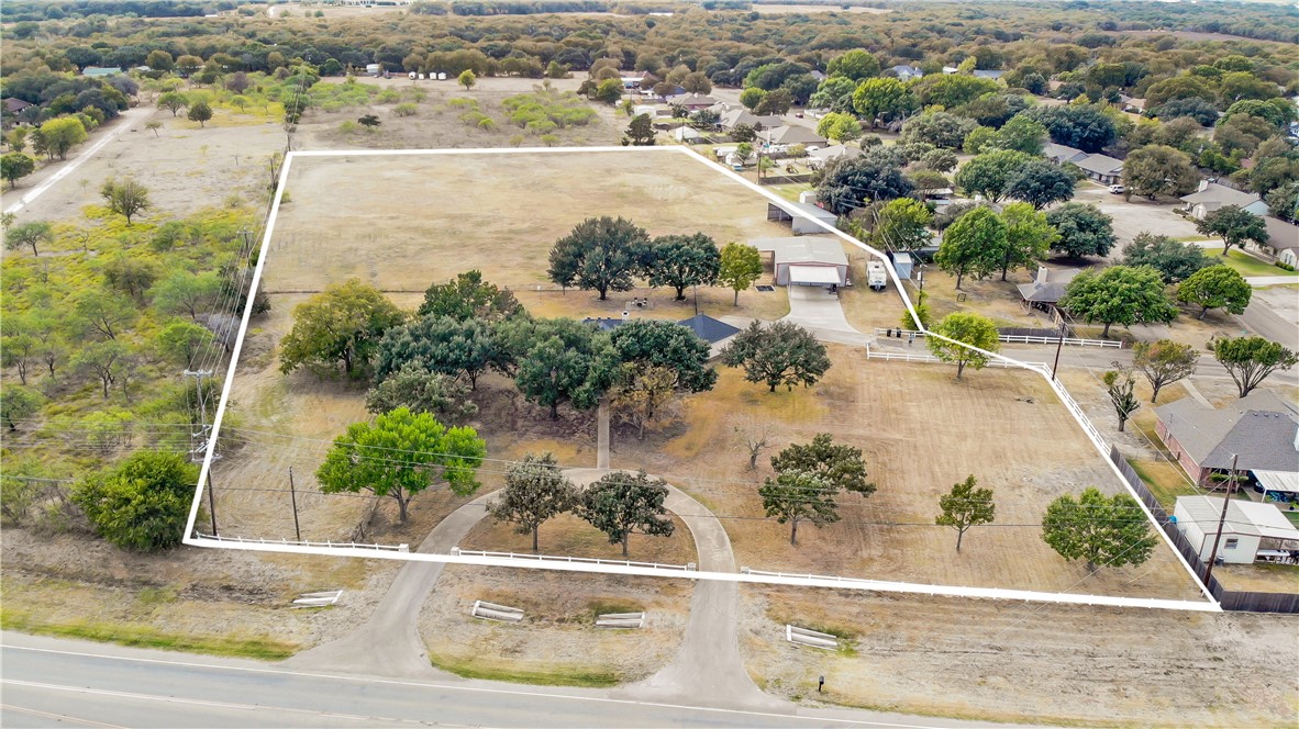 an aerial view of a house with a yard and lake view