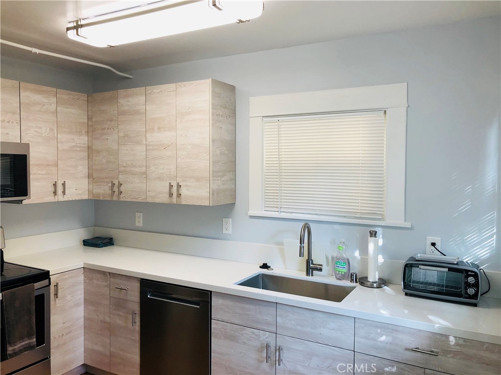 a kitchen with a sink and a stove next to a window