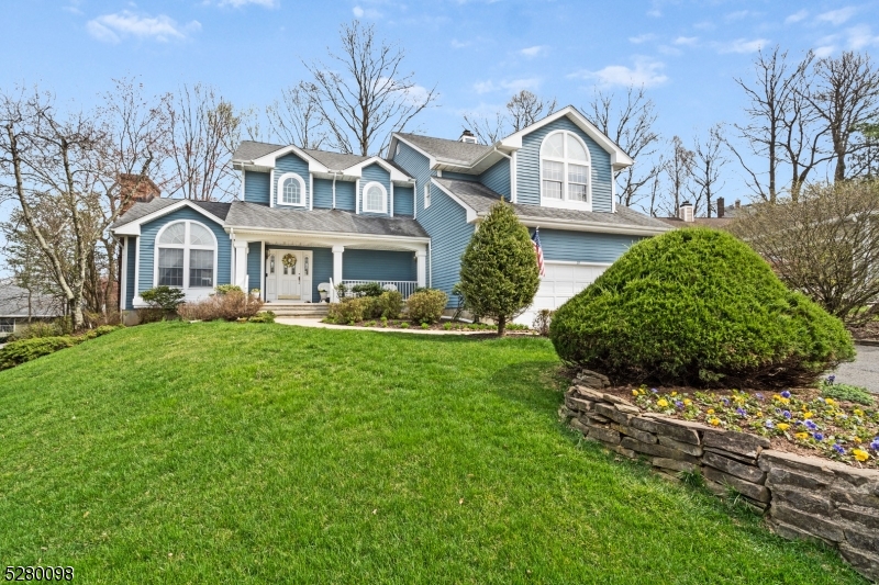 a front view of a house with a garden and plants