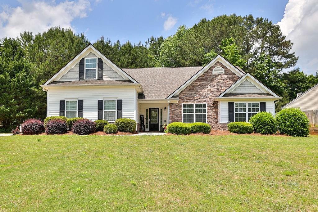 a front view of a house with yard and green space