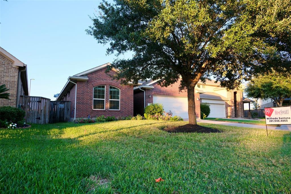 a front view of a house with a yard and trees