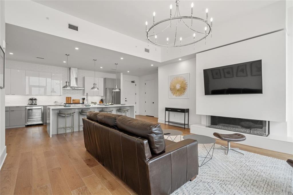 a living room with stainless steel appliances kitchen island furniture and a flat screen tv