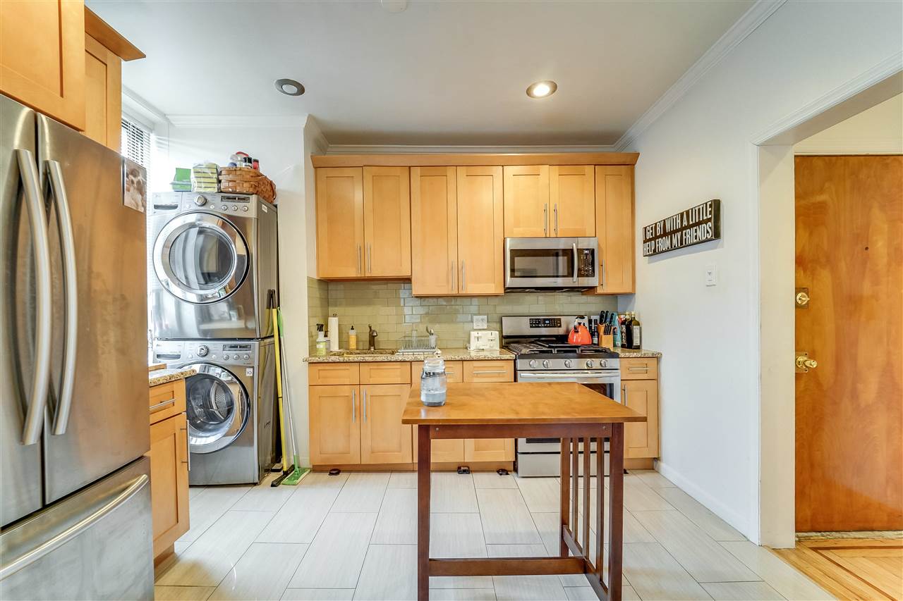 a kitchen with stainless steel appliances granite countertop a refrigerator and a stove top oven