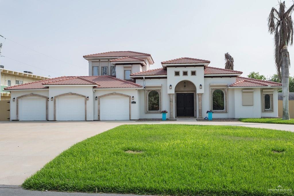 a front view of a house with a garden and yard