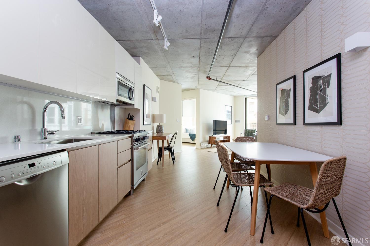 a kitchen with stainless steel appliances granite countertop a dining table chairs and sink