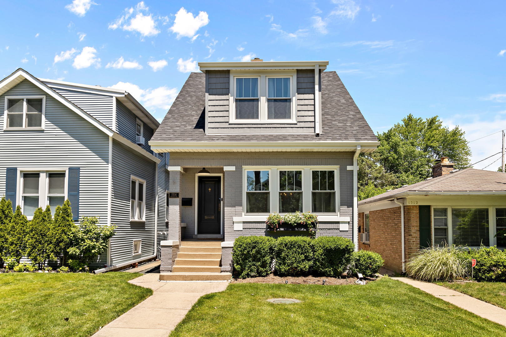 a front view of a house with garden and yard