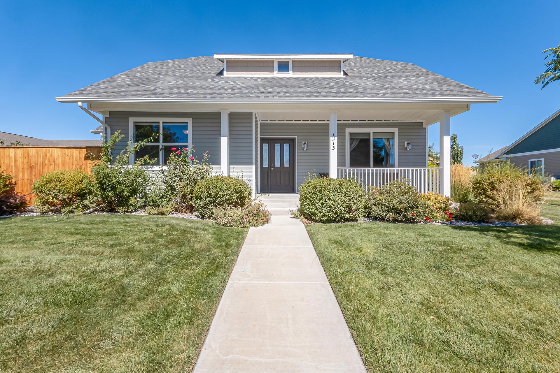 a front view of a house with yard and green space