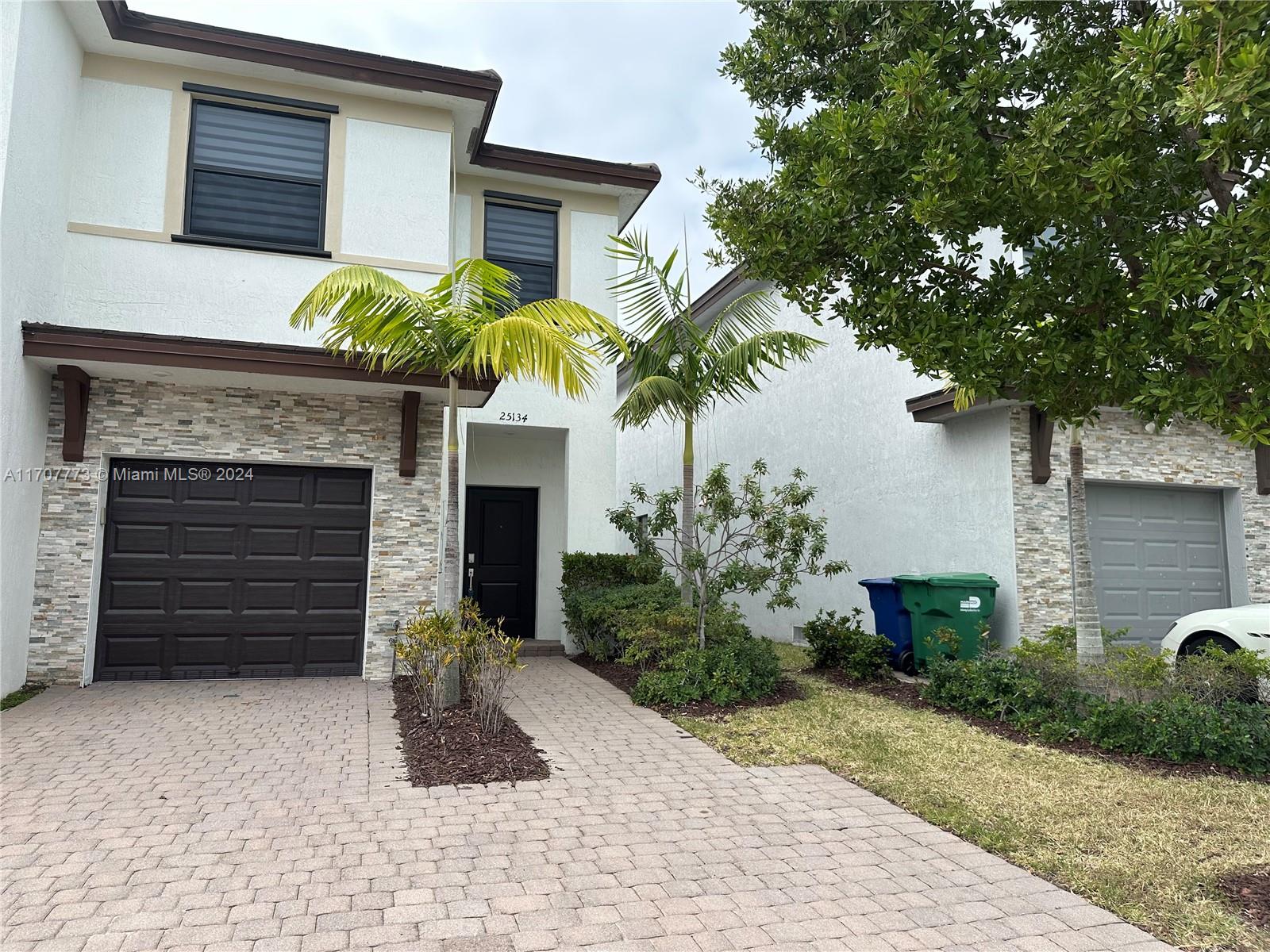 a front view of a house with a yard and garage