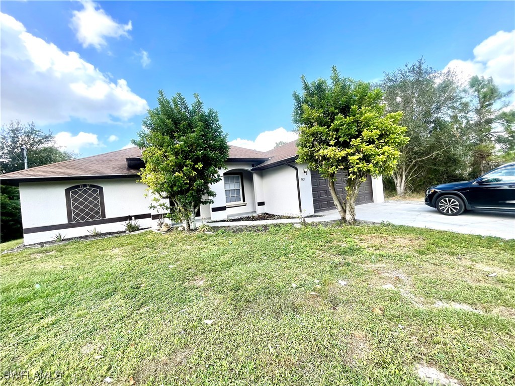 a view of a house with a yard and a garage