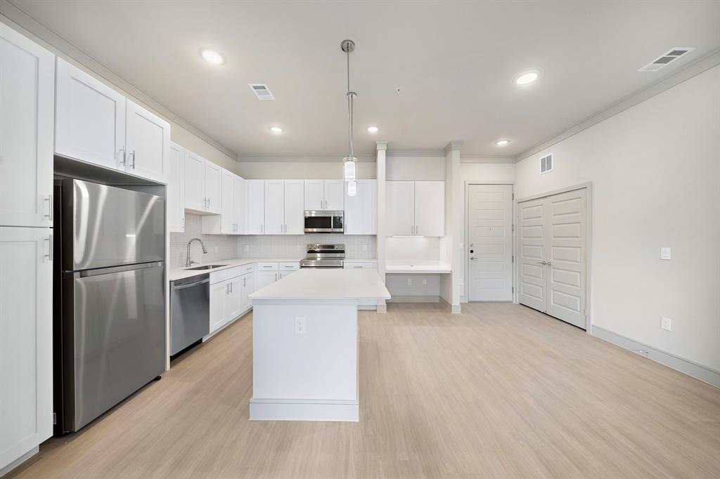 a kitchen with refrigerator and cabinets