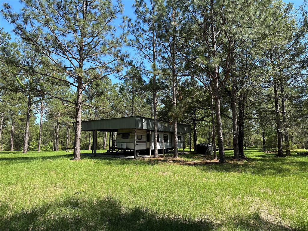 a view of a house with a big yard and large trees