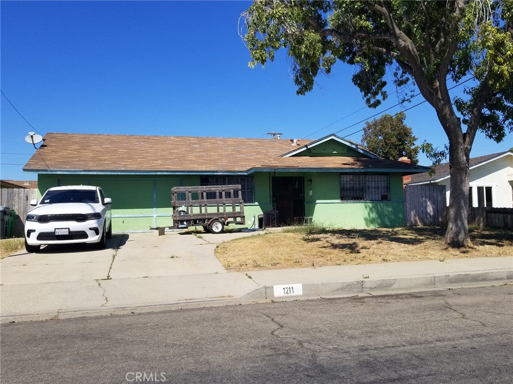 a view of a house with car parked on the road