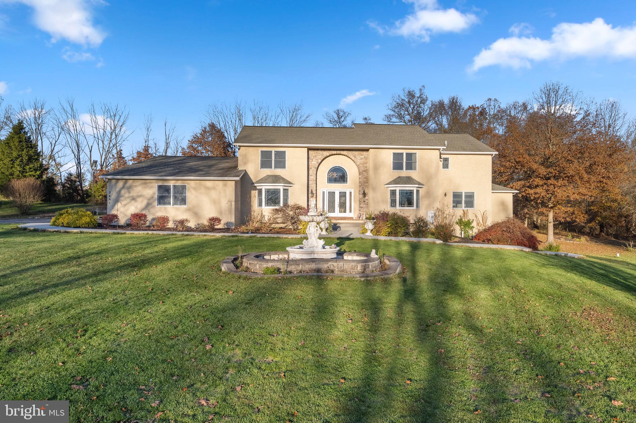 a front view of a house with garden and lake view