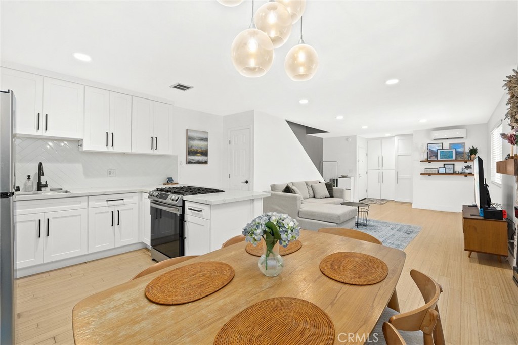 a kitchen with a stove a sink a dining table and chairs