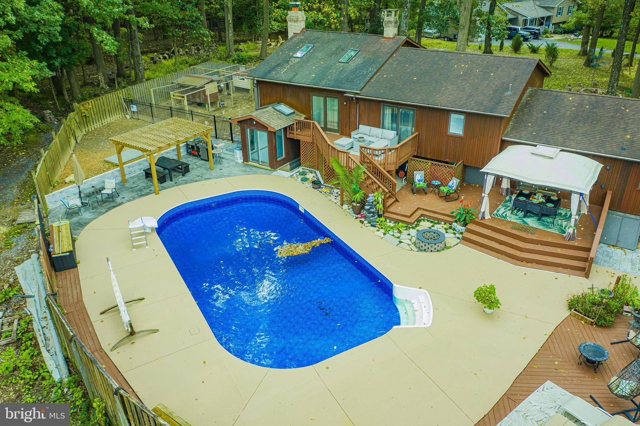 an aerial view of a house with swimming pool and outdoor seating