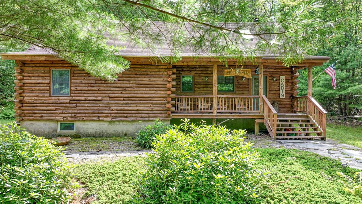 Log home featuring a porch