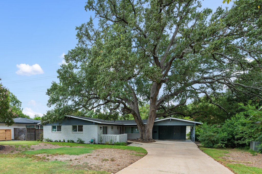 a front view of house with yard and trees