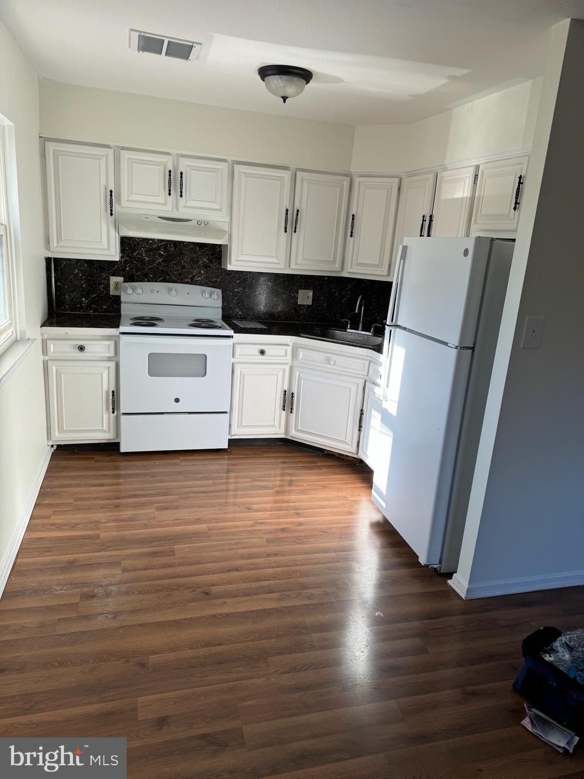 a view of kitchen with stainless steel appliances wooden floor and electronic appliances