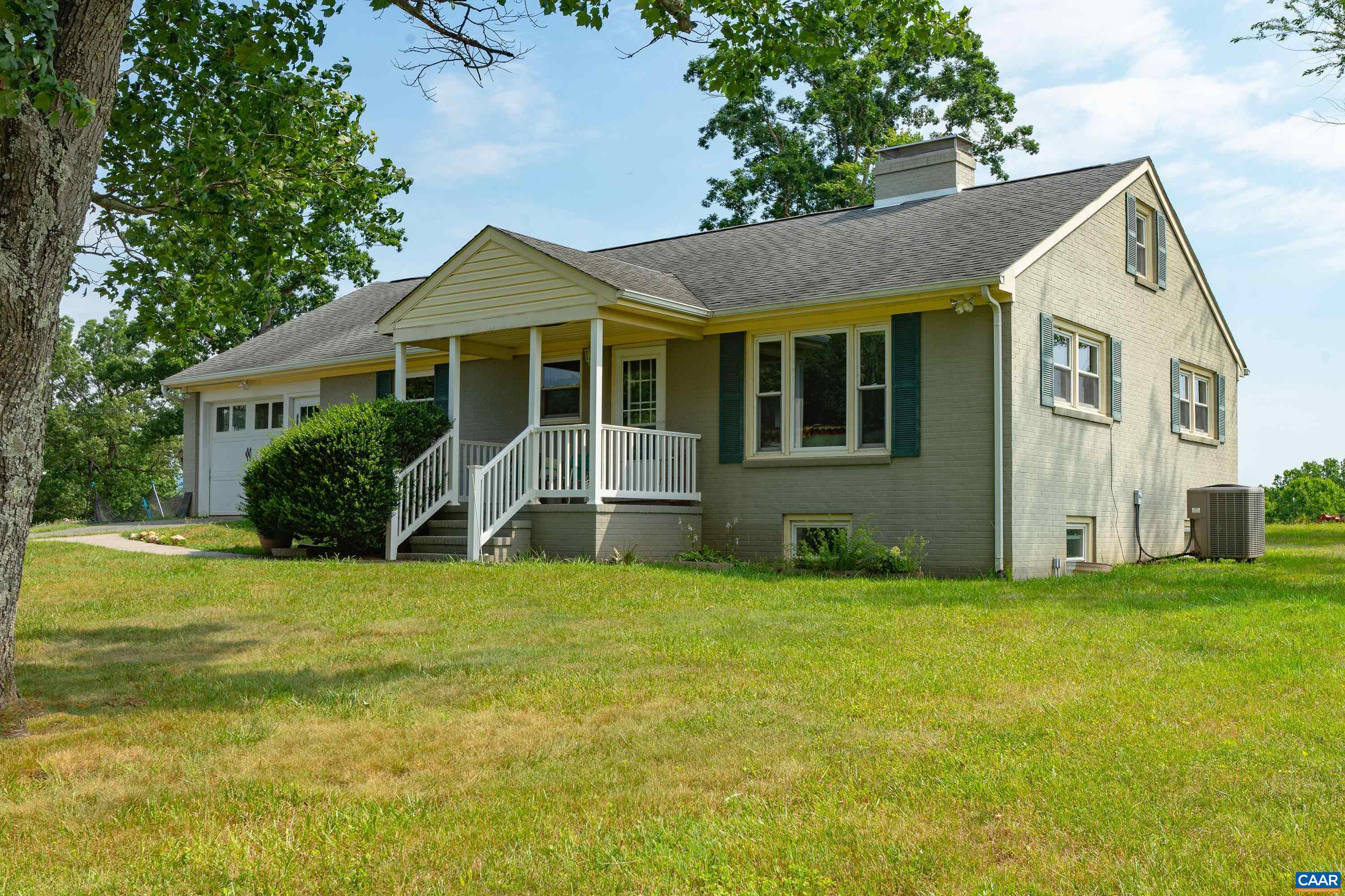 a view of a house with a yard and potted plants