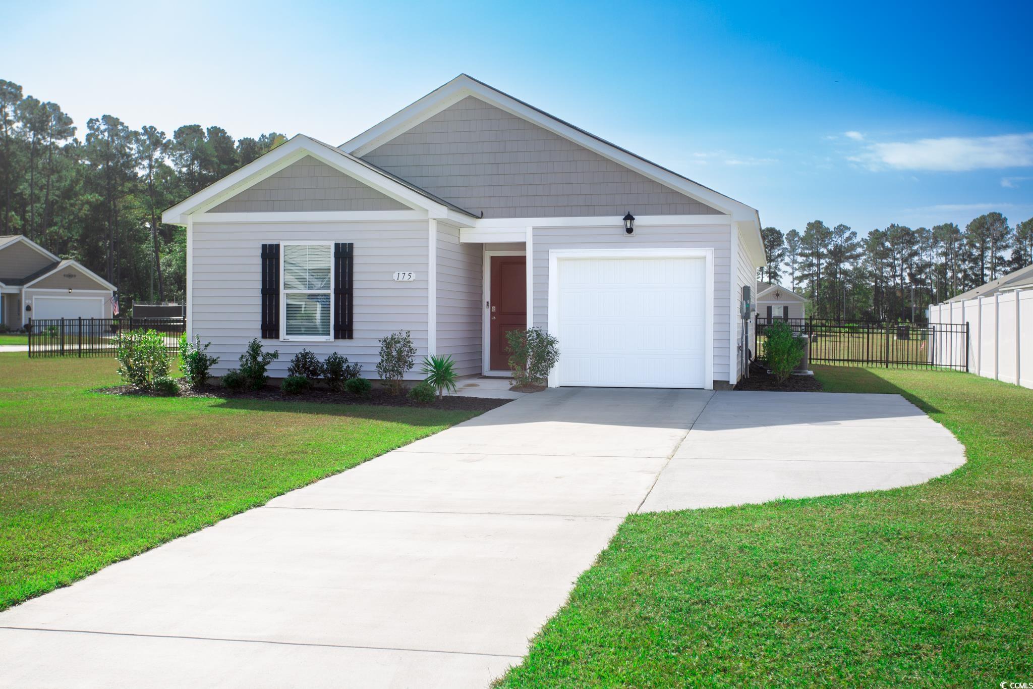 View of front of home with a garage and a front ya