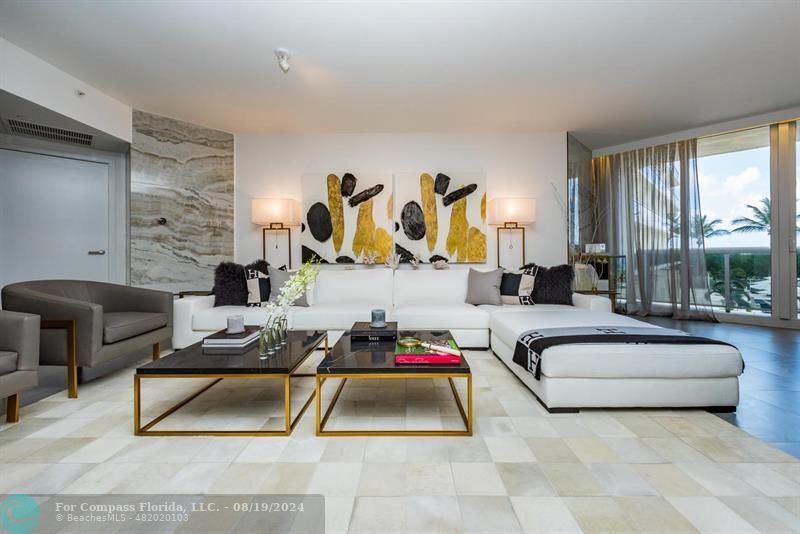 a living room with furniture and a floor to ceiling window